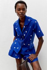 Profile view of model wearing the Oroton Embroidered Fruit Skort in Azure Blue and 100% cotton for Women