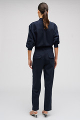 Profile view of model wearing the Oroton Tapered Pinstripe Pant in North Sea and 95% WOOL 5% ELASTANE for Women . IP:5