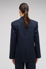 Profile view of model wearing the Oroton Pinstripe Blazer in North Sea and 95% WOOL 5% ELASTANE for Women . IP:5