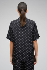 Profile view of model wearing the Oroton Long Belted Camp Shirt in Black/Cream and 100% Silk for Women .