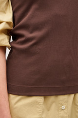 Profile view of model wearing the Oroton Lottie Rib Tank in Chocolate and 92% Cotton / 8% Spandex for Women .