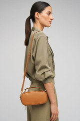 Profile view of model wearing the Oroton Margot Camera Bag in Dark Camel and Smooth Leather exterior for Women