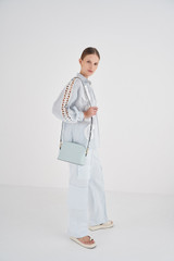 Profile view of model wearing the Oroton Inez Slim Crossbody in Duck Egg and Shiny soft saffiano leather for Women . IP:4