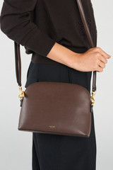 Profile view of model wearing the Oroton Inez Slim Crossbody in Coffee Bean and Shiny soft saffiano leather for Women . IP:4
