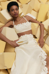 Profile view of model wearing the Oroton Rosebud Lace Skirt in Soft Cream and 100% linen material for Women . IP:6