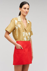 Profile view of model wearing the Oroton Pocket Detail Mini Skirt in Poppy and 100% linen material for Women . IP:4