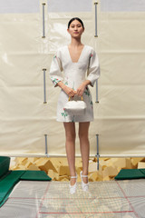 Profile view of model wearing the Oroton Rosebud Short Dress in Antique White and 100% linen material for Women . IP:6