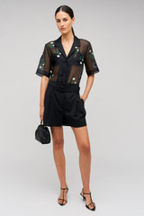 Profile view of model wearing the Oroton Rosebud Embroidery Camp Shirt in Black and 100% silk material for Women