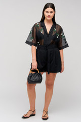 Profile view of model wearing the Oroton Rosebud Embroidery Camp Shirt in Black and 100% silk material for Women