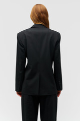 Profile view of model wearing the Oroton Wrap Blazer in Black and 98% wool,  2% elastane material for Women .
