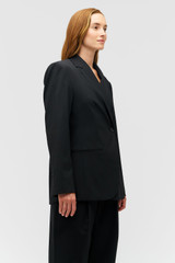 Profile view of model wearing the Oroton Wrap Blazer in Black and 98% wool,  2% elastane material for Women .