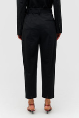 Profile view of model wearing the Oroton Tapered Pleat Pant in Black and 98% wool 2% elastane material for Women . IP:5