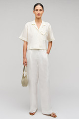Profile view of model wearing the Oroton Rosebud Lace Camp Shirt in Soft Cream and 100% linen material for Women