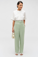 Profile view of model wearing the Oroton Lace Trim Smock Top in White and 100% linen for Women