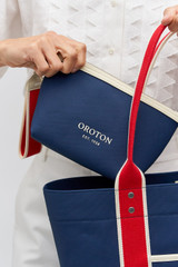 Profile view of model wearing the Oroton Crew Pouch in Prussian Blue Mix and Canvas exterior for Women