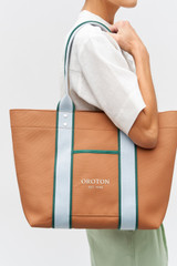 Profile view of model wearing the Oroton Crew Tote in Dark Camel Mix and Canvas material for Women