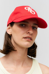 Profile view of model wearing the Oroton Oro Logo Cap in Market Red and High-quality 100% cotton material for Women