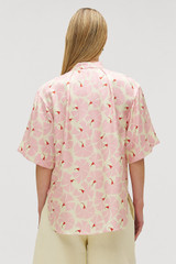 Profile view of model wearing the Oroton Fan Flower Tie Neck Blouse in Peony and 100% silk for Women .