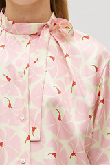 Profile view of model wearing the Oroton Fan Flower Tie Neck Blouse in Peony and 100% silk for Women .