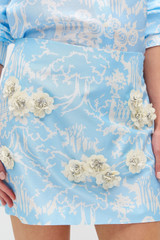 Profile view of model wearing the Oroton Garden Toile Embellished Mini Skirt in Sky and 100% silk for Women