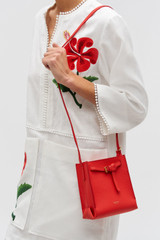 Profile view of model wearing the Oroton Margot Tiny Bucket Bag in Chilli Pepper and Smooth Leather for Women