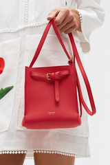 Profile view of model wearing the Oroton Margot Tiny Bucket Bag in Chilli Pepper and Smooth Leather for Women