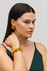 Profile view of model wearing the Oroton Urchin Bracelet in Worn Gold and Premium brass material for Women . IP:2