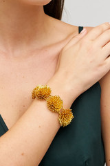 Profile view of model wearing the Accessories Urchin Bracelet in Worn Gold and Brass for Women