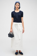Profile view of model wearing the Oroton Clover Poplin Skirt in White and 100% Cotton for Women