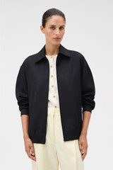 Profile view of model wearing the Oroton Bomber in Black and 100% wool material for Women . IP:4