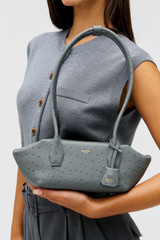 Profile view of model wearing the Oroton BREEZE TEXTURE BAGUETTE in Dark Slate and Embossed leather for Women