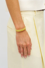 Profile view of model wearing the Oroton Naia Narrow Cuff in Worn Gold and Brass material for Women . IP:2