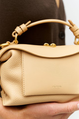 Profile view of model wearing the Oroton Mica Mini Bowler in Biscotti and Premium pebble leather for Women . IP:5