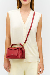 Profile view of model wearing the Oroton Mica Mini Bowler in Cherry and Premium pebble leather for Women . IP:4