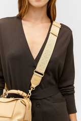 Profile view of model wearing the Oroton Logo Bag Strap in Biscotti and Premium leather and webbing material for Women . IP:2