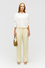 Profile view of model wearing the  DOILIE DETAIL TOP in Antique White and 100% linen fabric for Women