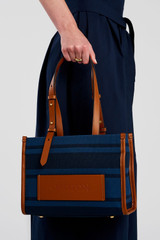 Profile view of model wearing the Oroton Sasha Small Tote in PRUSSIAN BLUE MIX and 100% polyester fabric for Women .
