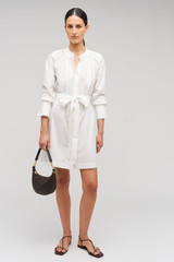 Profile view of model wearing the Oroton Lace Detail Smock Dress in White and 100% cotton material for Women