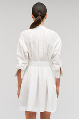 Profile view of model wearing the Oroton Lace Detail Smock Dress in White and 100% cotton material for Women