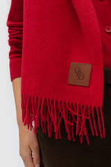 Profile view of model wearing the Oroton WOVEN WOOL SCARF in MARKET RED and 100% wool fabric for Women