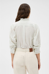 Profile view of model wearing the Oroton MINI DOT RUFFLE BLOUSE in Antique White and 100% cotton fabric for Women