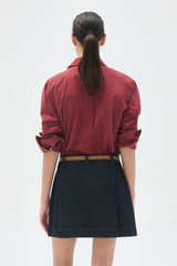 Profile view of model wearing the Oroton Wren Poplin Shirt in Rouge and Made from 100% poplin cotton  for Women