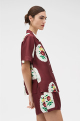 Profile view of model wearing the Oroton Folk Doilie Camp Shirt in Burgundy and 100% silk twill fabric for Women . IP:3