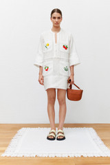 Profile view of model wearing the Oroton Embroidered Tunic Dress in Antique White and 100% linen for Women .