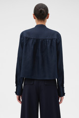Profile view of model wearing the Oroton Doilie Detail Top in NORTH SEA and 100% linen fabric for Women . IP:5