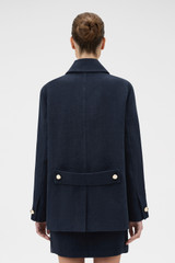 Profile view of model wearing the Oroton Button Detail Jacket in NORTH SEA and 100% bonded heavy linen fabric for Women . IP:4