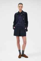 Profile view of model wearing the Oroton Button Detail Mini Skirt in NORTH SEA and 100% bonded salt-washed linen fabric for Women . IP:6