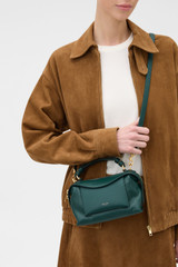 Profile view of model wearing the Oroton Mica Mini Bowler in IVY and Premium pebble leather for Women . IP:4