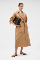 Profile view of model wearing the Oroton Linen Trench in CAMEL and 100% heavyweight linen fabric for Women . IP:6