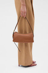 Profile view of model wearing the Oroton Cali Baguette in AMBER and Premium smooth leather for Women . IP:2